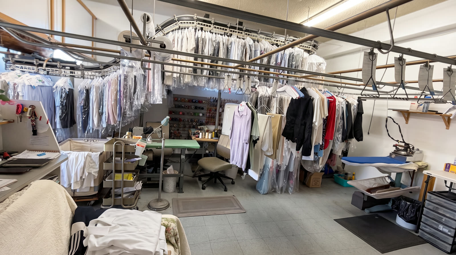 Conveyor racks and pressing equipment in the Style Cleaners workroom